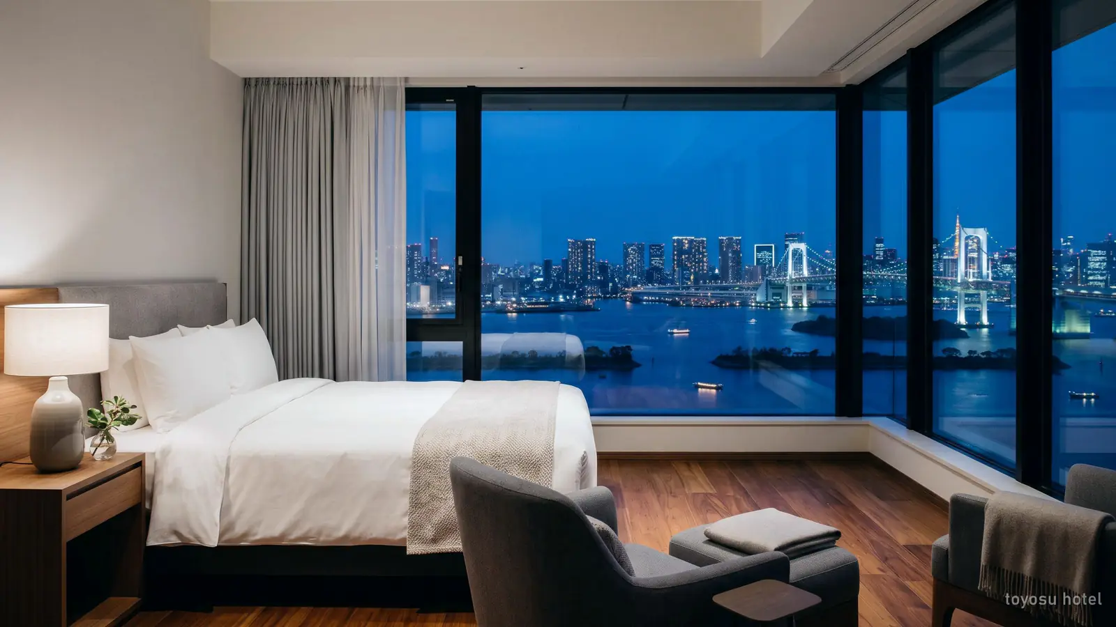 Illustration: a modern hotel room with a window over Tokyo Bay at dusk, like the high-floor hotels in Toyosu